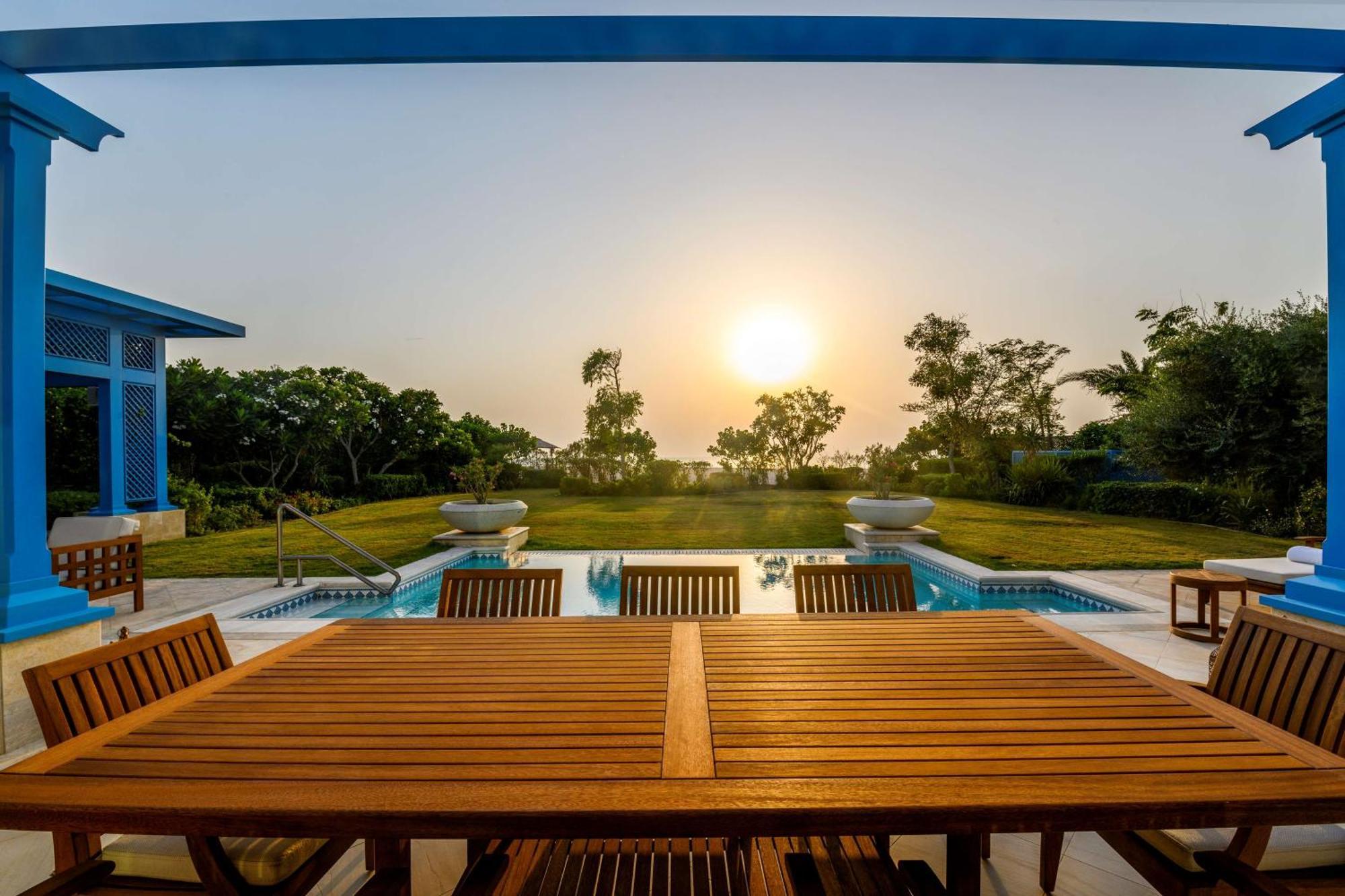 Hilton Salwa Beach Resort And Villas Abu Samra Exterior foto Sunset at the pool